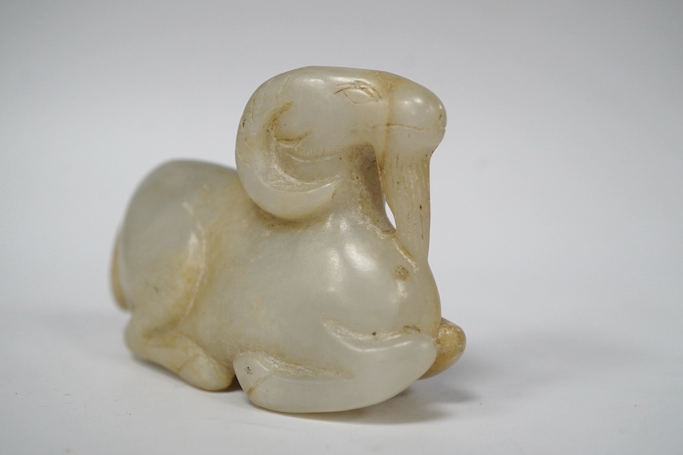 A Chinese pale green jade gourd pendant, a Chinese jade white and russet jade figure of a recumbent goat and a Chinese hardstone recumbent figure of an ox, largest 6cm wide (3)., Condition - good